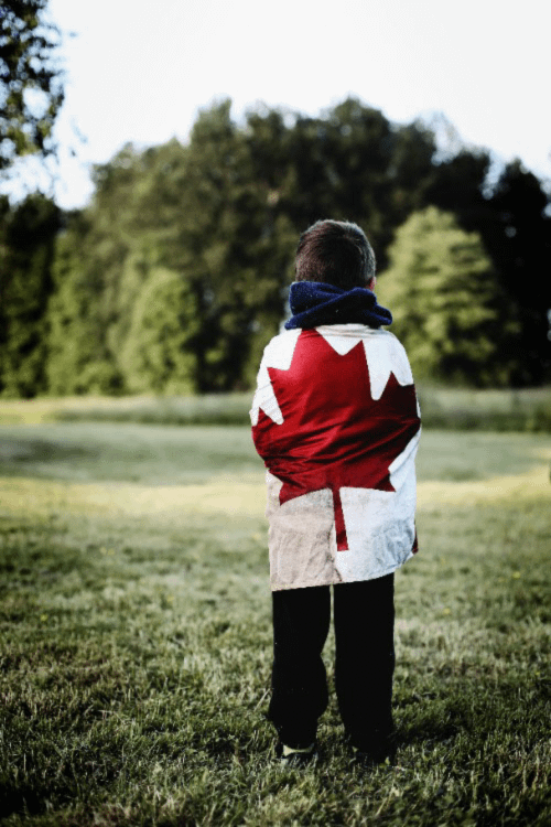 A child with the Canadian flag wrapped around his body